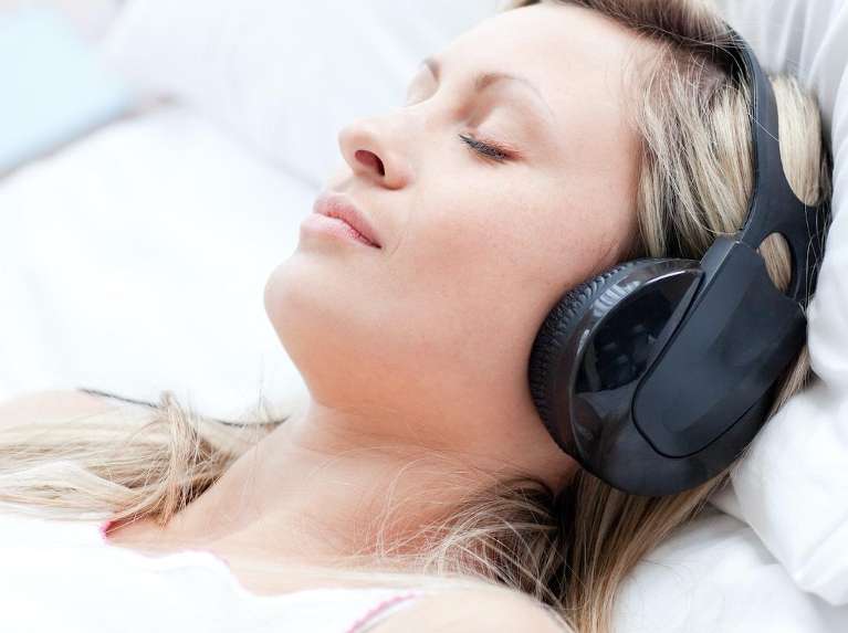 Woman lying down with noise canceling headphones on, ashburn va
