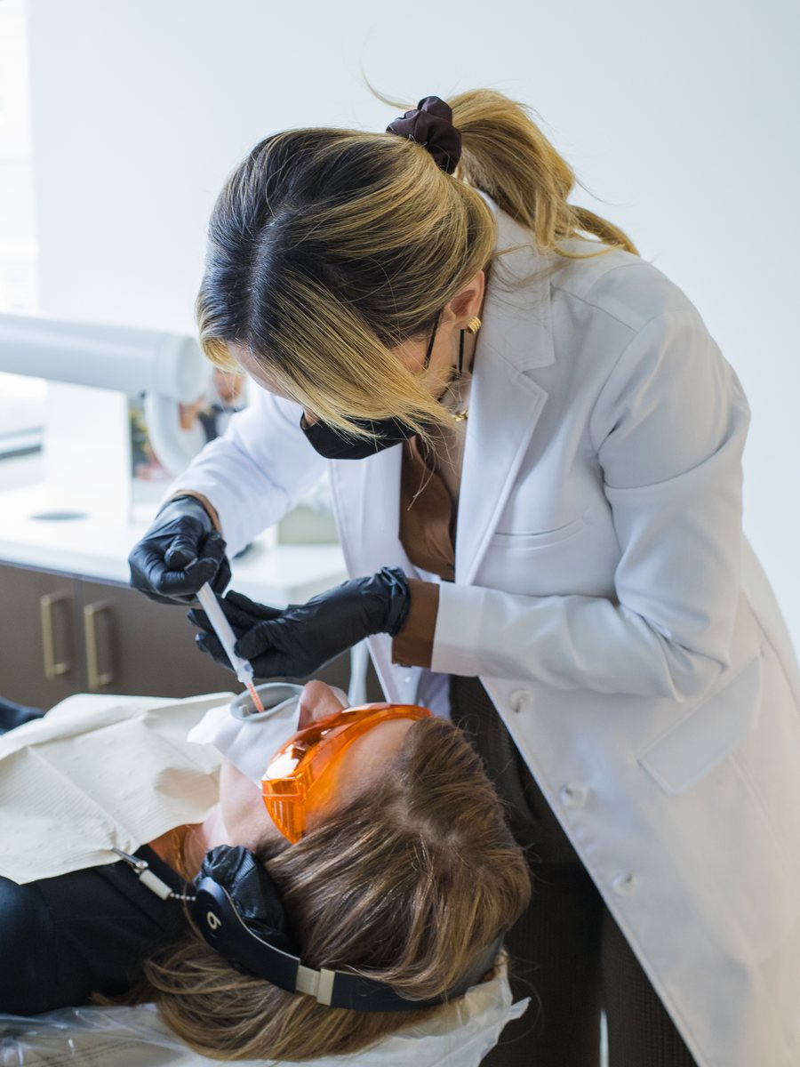 Dr. Fatemeh Baftechi applying professional whitening gel to a patient at POSH Smiles in Ashburn, VA